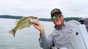 Jimbo holding a spotted bass over the edge of his boat